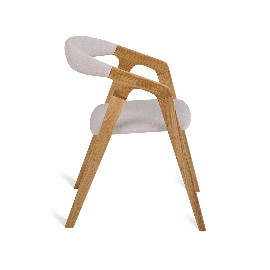 Oak dining chair side view showing soft beige fabric and slim frame