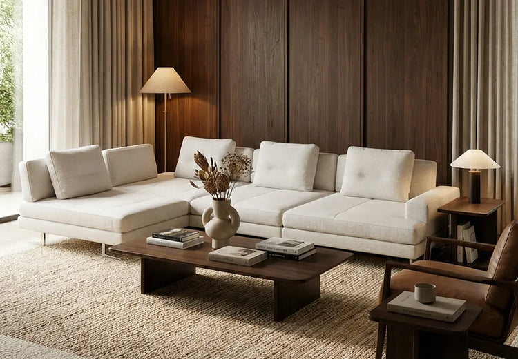 Cream sectional sofa against dark wood paneling, with a coffee table and floor lamp