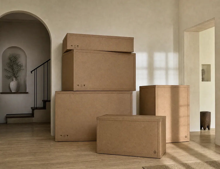 A neatly stacked arrangement of sturdy, eco-friendly cardboard delivery boxes from Verdant Furniture, placed in a bright, modern home entryway.