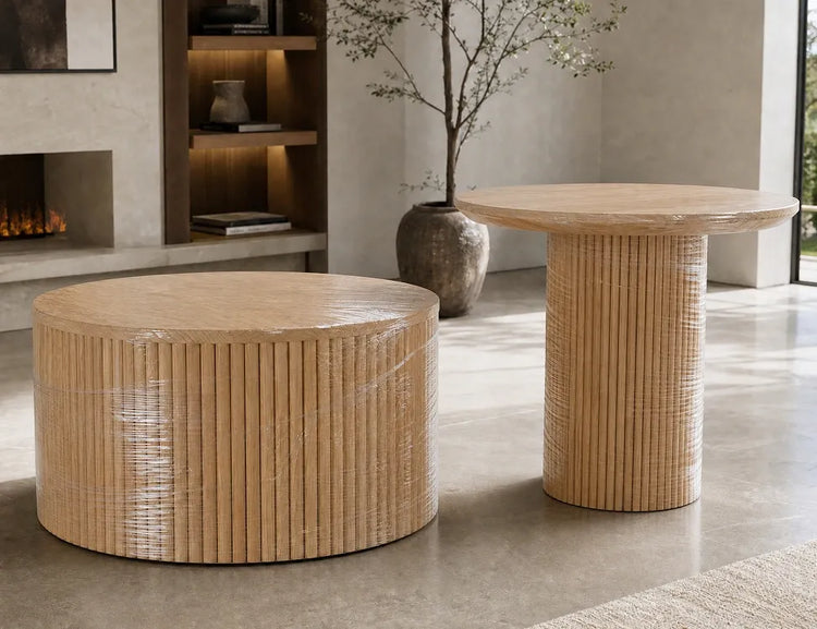 Two round wooden coffee tables with a modern fluted texture by Verdant Furniture, protected in clear plastic wrap in a stylish living room setting.
